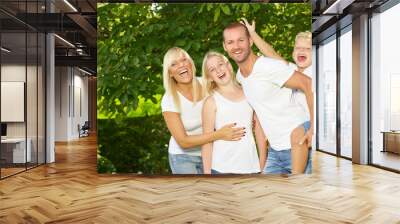 Parents giving piggyback ride to children Wall mural