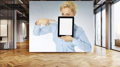 Woman pointing a finger at her tablet pc with copyspace Wall mural