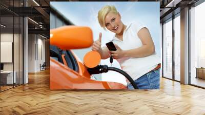 woman with cellphone loading electrically powered car Wall mural