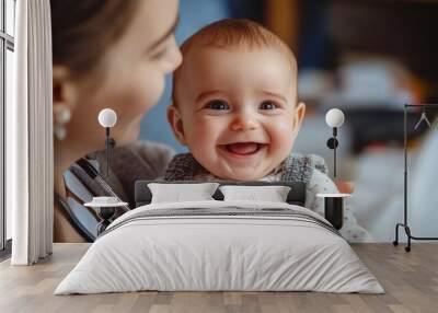 Smiling baby held by caregiver in a warm indoor setting Wall mural