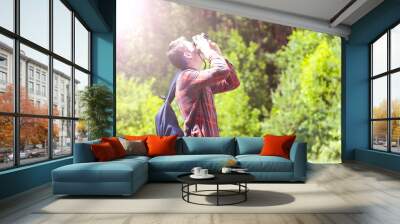 A young man takes photos of nature. Summer-Autumn. Wall mural