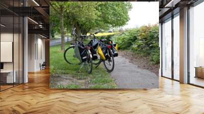 Pair of two bikes with panniers on grass near path Wall mural