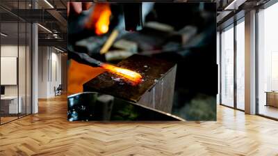 Japanese blacksmith is hammering the hot red steel to make a small Japanese sword.  Wall mural