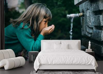 girl drinking water from a fountain Wall mural