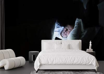 Man using his phone in his bed instead of sleeping, technology addiction concept Wall mural