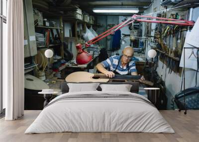 Man working at a Workshop with Musical instruments Wall mural