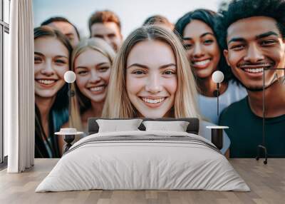 Diverse group of young adults smiling at the camera, symbolizing unity, friendship, and multicultural diversity in an outdoor setting with natural light. Wall mural