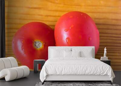 two red tomatoes on a brown wooden board, drops of water on a tomato, close-up, vegetables Wall mural