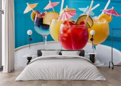 A closeup of delicious iced fruit cocktails with straws on the table against a blue background Wall mural