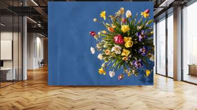 Bouquet of spring flowers on a blue background top view Wall mural