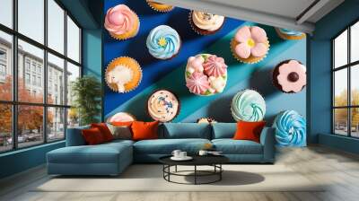 Flat lay with various arranged sweet cupcakes isolated on blue Wall mural