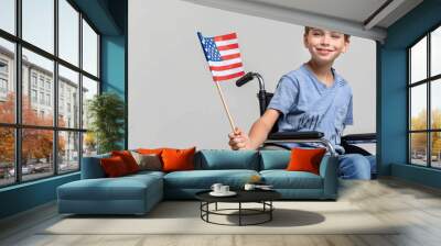 Young boy in wheelchair holding american flag smiling at camera Wall mural