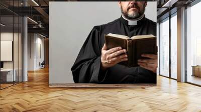 Young priest reading holy Bible isolated on white background. Wall mural