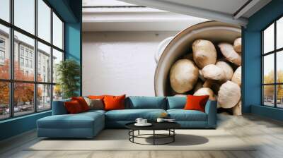 champignon mushrooms in an iron pan on a white windowsill. village concept Wall mural