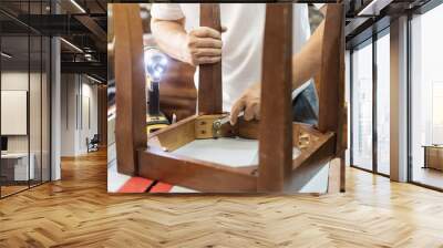 carpenter repair chair using Wrench at workshop, furniture restoration woodworking concept. selective focus Wall mural