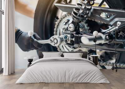 Mechanic using a wrench and socket to Remove and Replace Rear Motorcycle Wheel  , maintenance, repair motorcycle concept in garage .selective focus Wall mural