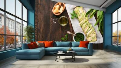 Braided wild garlic pesto brioche. Homemade fresh pull apart bread with wild garlic pesto on wooden board on wooden background table. Italian bread. Copy space. Top view. Wall mural