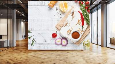 Cooking Background with spices: pepper, rosemary, paprika, lemon, onion, asparagus, olive oil, tomato, parmesan cheese, cooking board and napkin on old wooden background. Culinary banner. Top view. Wall mural