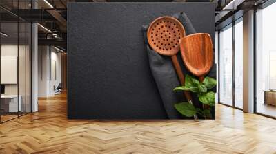 Cooking wooden utensils, basil leaves and spices on dark stone background. Abstract food background. Top view of dark rustic kitchen table with wooden cooking spoon, frame. Banner for your design. Wall mural