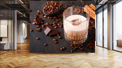 Glass of Irish cream baileys liqueur with roasted coffee beans, cinnamon and chocolate on dark wood background table. Selective focus. Wall mural