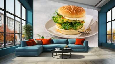 Healthy Vegetarian burger with egg and pea shoots and seeds microgreen, fresh salad, cucumber slice on a cutting wooden board on light background. Selective focus Wall mural