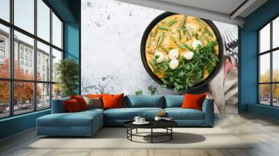 Omelet with spinach, green beans, potato and spinach healthy food in black frying pan on grey stone old rustic background. Traditional frittata for breakfast Eggs tortilla Top view flat lay Copy space Wall mural