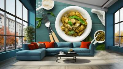 Potato gnocchi. Traditional homemade potato gnocchi with sauce pesto, kitchen table and basil on old rustic turquoise kitchen table. Traditional Italian food. Traditional Italian food. Top view. Wall mural