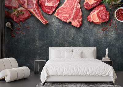 Raw prime steaks. Variety of fresh black angus prime meat steaks T-bone, New York, Ribeye, Striploin, Tomahawk on black or gray stone background. Set of various classic steaks. Top view, copy space. Wall mural