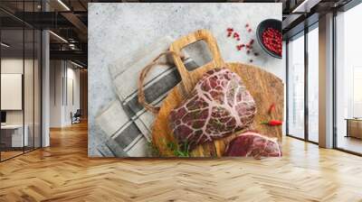 Steaks Raw. Raw cowboy steak, marbled beef meat with spices rosemary and pepper on old wooden board on old grey slate table background. Top view. Mock up. Wall mural