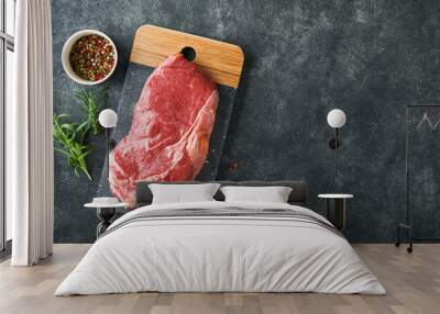 Steaks. Fresh New York Steaks raw with spices rosemary and pepper on black marble board on gray background. Top view. Mock up. Wall mural