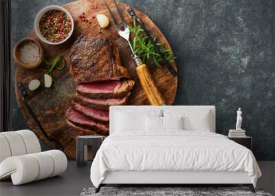 Steaks. Sliced grilled meat steak New York or Striploin with spices rosemary and pepper on black marble board on old stone grey background. Top view. Mock up. Wall mural