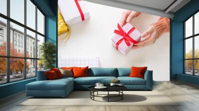 hand holding gift to prepare with present, ornament decoration on table. christmas, new year, and birthday celebration concept. Wall mural