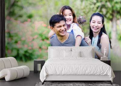 Cheerful family having picnic relaxing together on green nature in park Wall mural