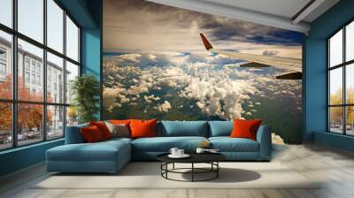 View of airplane wing cloudy blue sky and earth from airplane window Wall mural