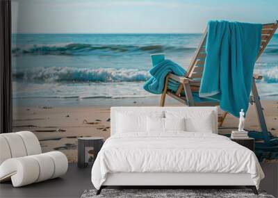 A beach chair with a builtin cup holder and a bright beach towel draped over it, near the ocean waves2 Wall mural