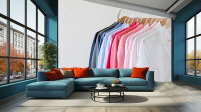 Different colored shirts hanging on rack Wall mural