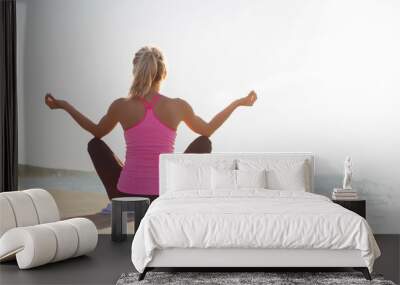 Silhouette of healthy woman practicing yoga on the beach Wall mural