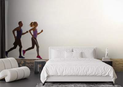 Silhouettes of man and woman running at sunset Wall mural