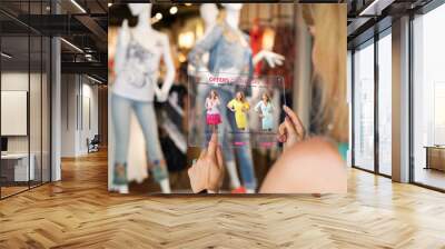 Woman using futuristic technology while shopping for new clothes in store Wall mural