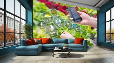 Woman using smart tech for greenhouse plant management Wall mural