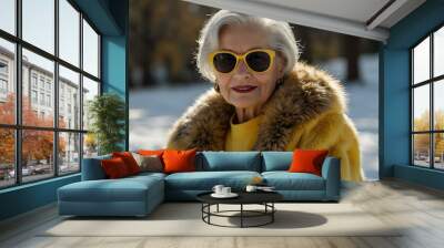 An elderly woman in a fur coat and yellow top, wearing sunglasses. Wall mural