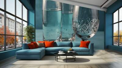 Crystal-clear water glasses on a pastel blue background. Wall mural