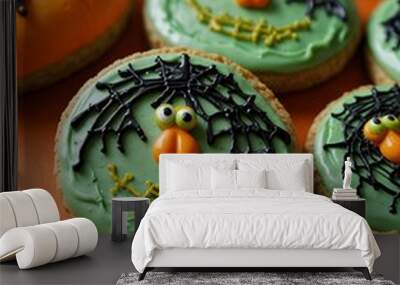 Halloween cookies with orange and green icing on an orange background. Wall mural