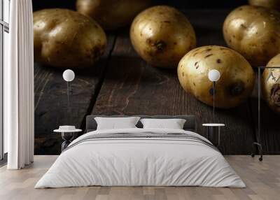 Potatoes arranged on a dark wooden surface, ideal for recipe advertising with space for text. Wall mural