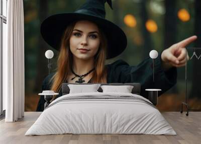 Young woman witch pointing during Halloween. Wall mural