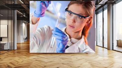 Attractive young scientist pipetting. Wall mural