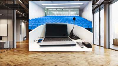 Laptop on the rostrum in conference hall. Wall mural