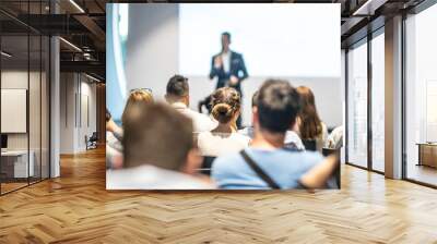 Male speaker giving a talk in conference hall at business event. Audience at the conference hall. Business and Entrepreneurship concept. Focus on unrecognizable people in audience. Wall mural