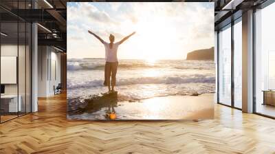 Relaxed woman enjoying sun, freedom and life an beautiful beach in sunset. Young lady feeling free, relaxed and happy. Concept of vacations, freedom, happiness, enjoyment and well being. Wall mural