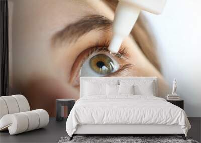 woman applying eye drop. vitamin drops from tiredness and redness eyes. suffering from irritated eye Wall mural